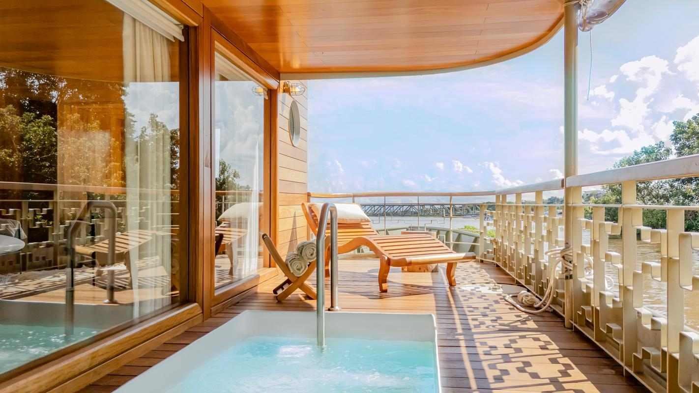 A private terrace on Delfin I with a private plunge pool, wooden deck, and lounge chairs overlooking a tropical river.