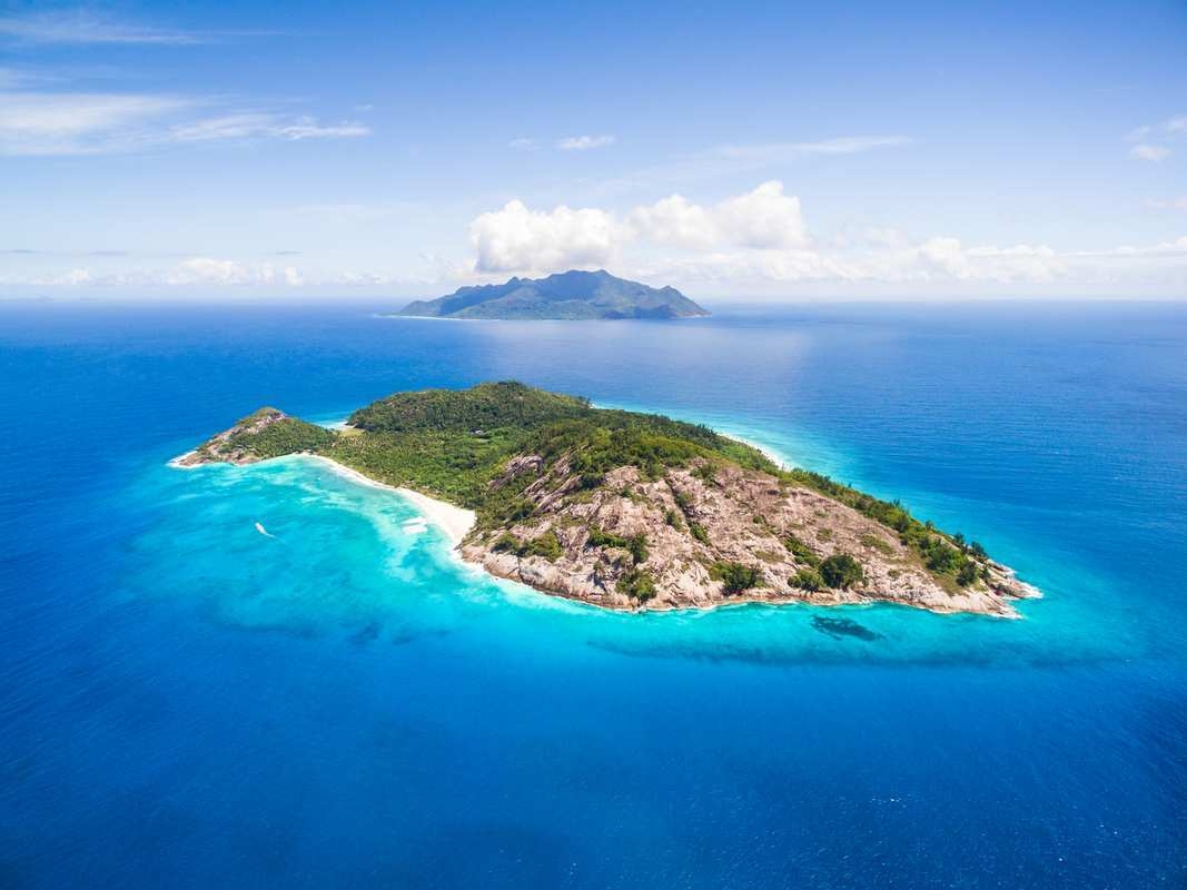 Aerial view of North Island with white sand beaches and clear blue water under a bright sky.