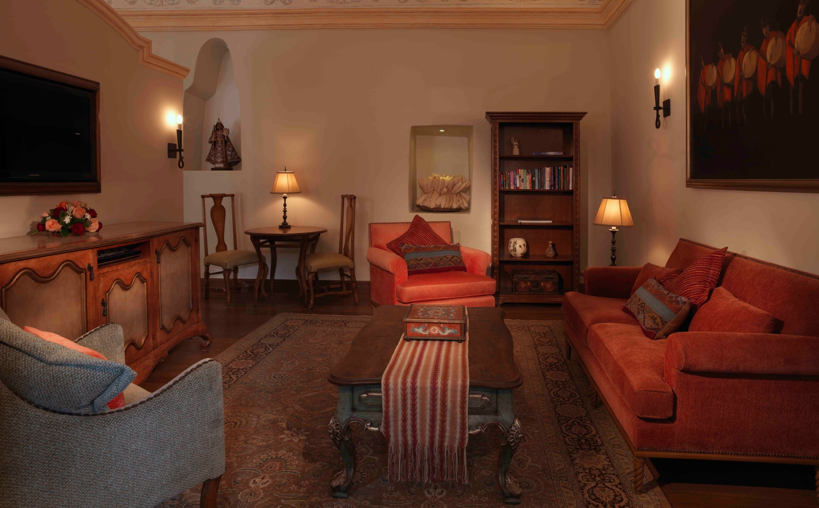 Elegant living room with warm lighting, classic furniture, and decorative artwork.