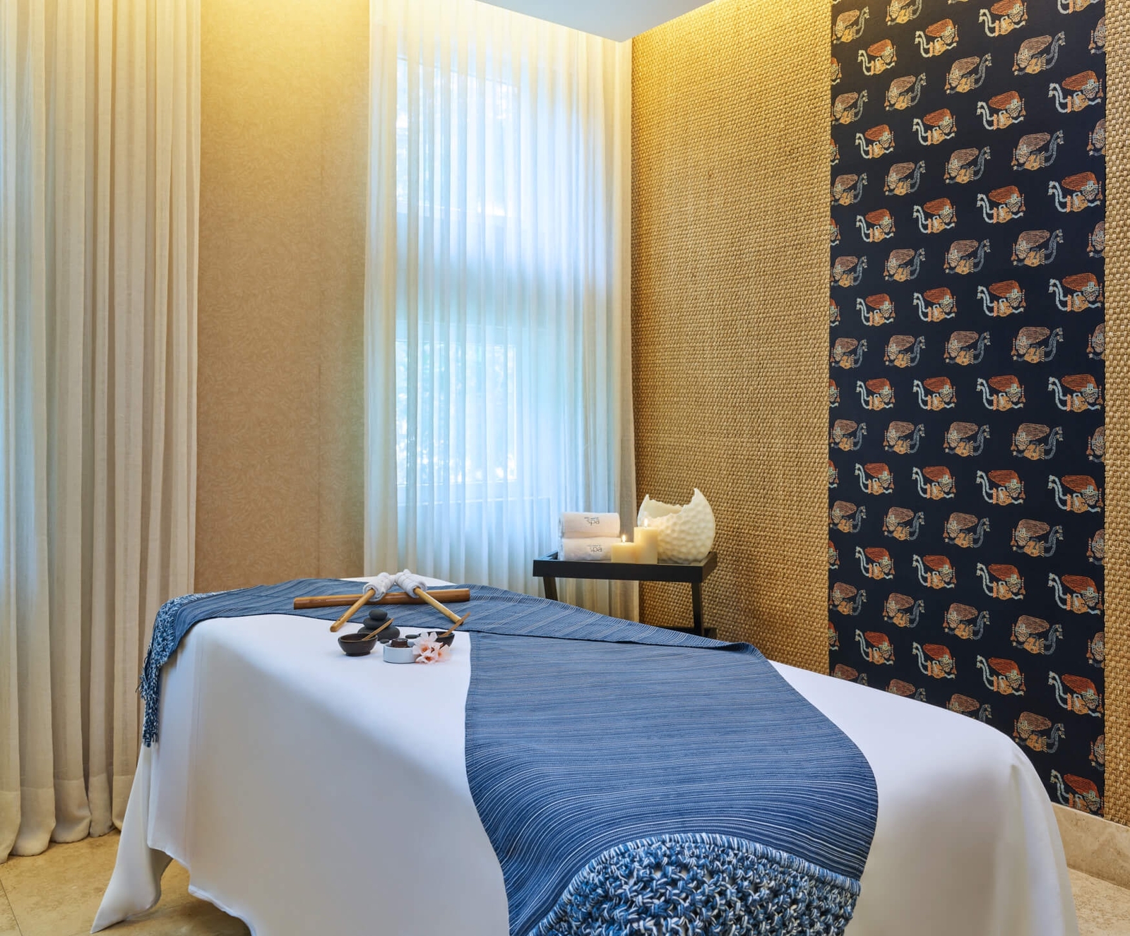 A serene spa room with a massage table, clean linens, and calming decor.