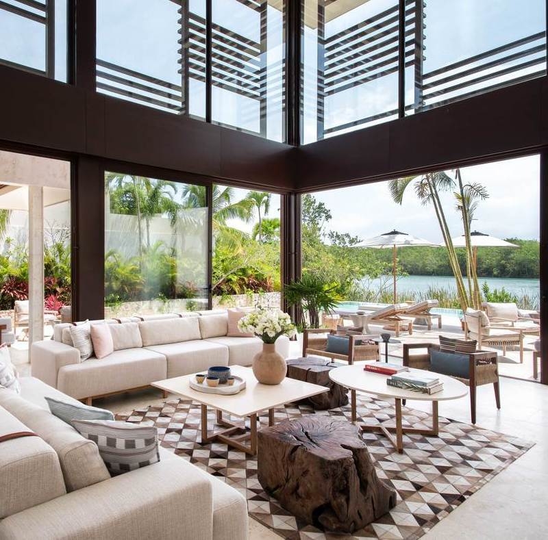 The living room interior of one of Rosewood Mayakoba's lagoon suites, featuring high ceilings and a view of the lagoon.