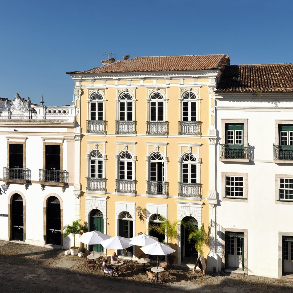 Street view of the yellow facade of Villa Bahia, Salvador