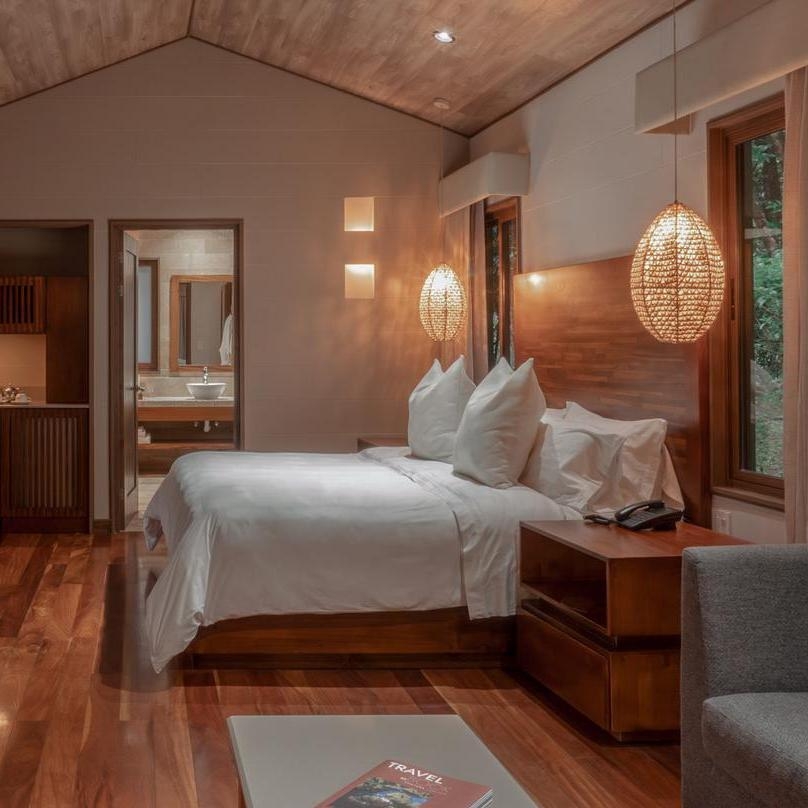 A suite's bedroom at El Silencio in Costa Rica decorated in hues and textures that reflect its forested setting.