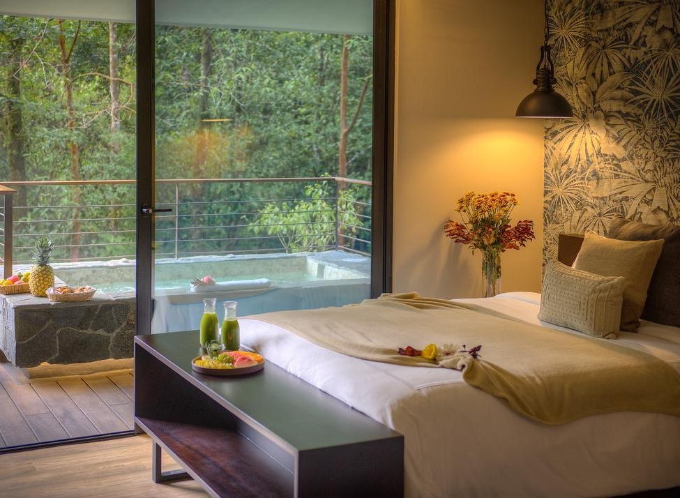 A villa's bedroom at El Silencio in Costa Rica overlooking a Jacuzzi on its adjoining deck.