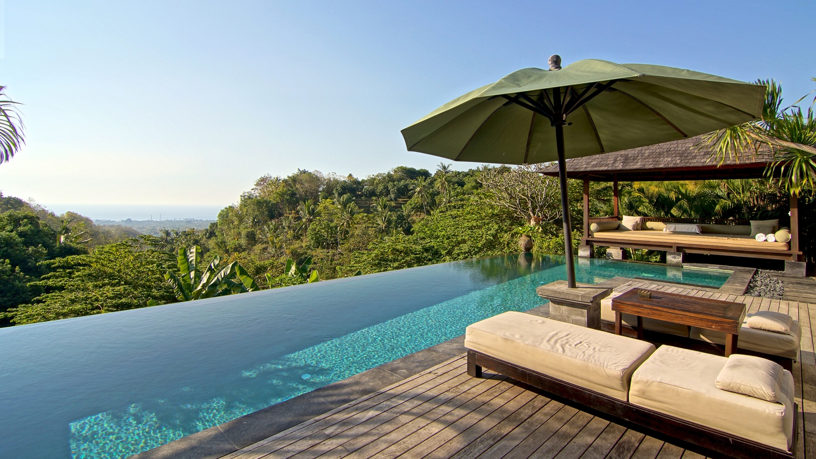 An infinity pool and lounge area at a tropical resort during luxury Bali trips.