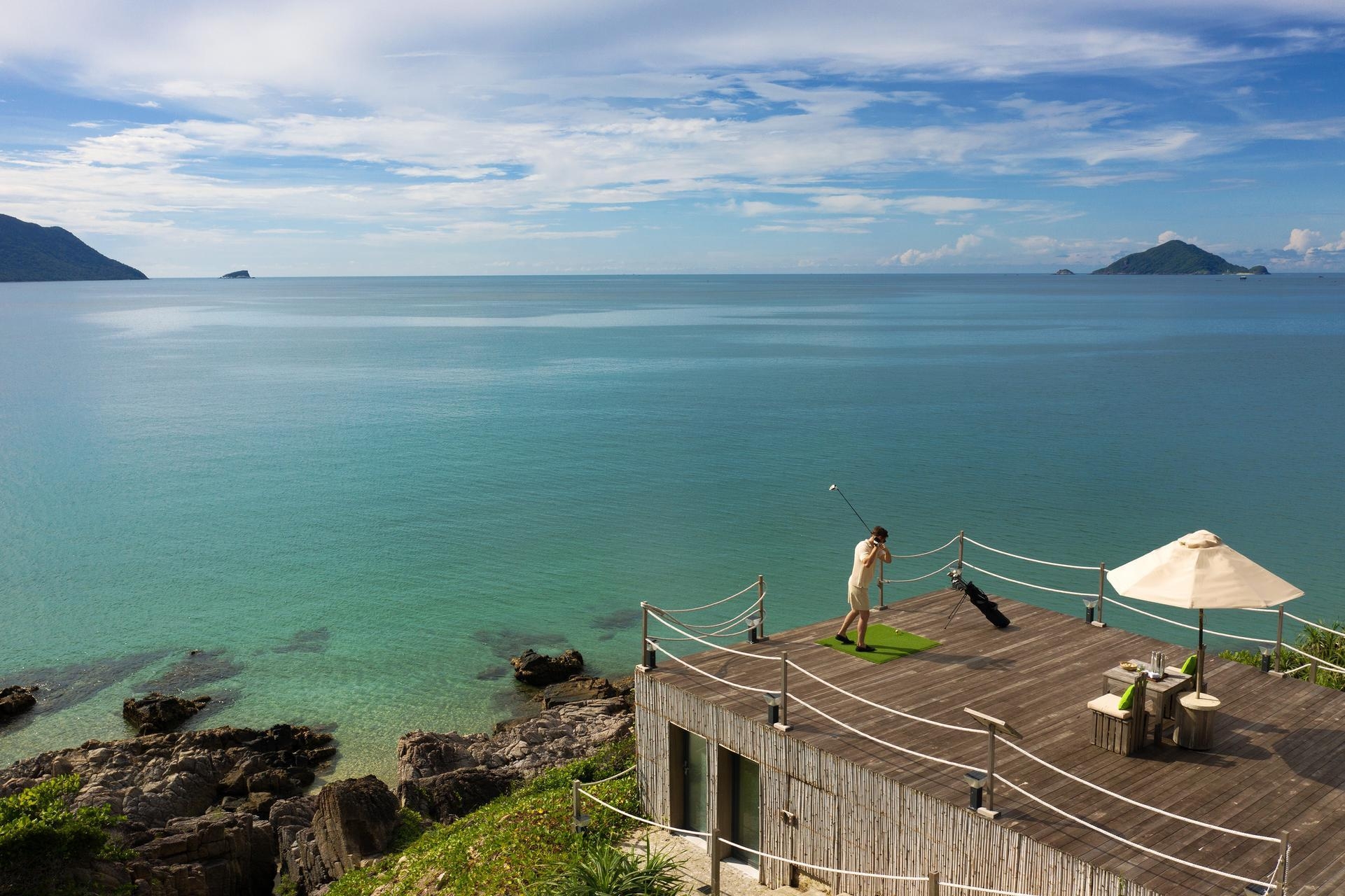 A man playing feed the fish golf at Six Senses Con Dao