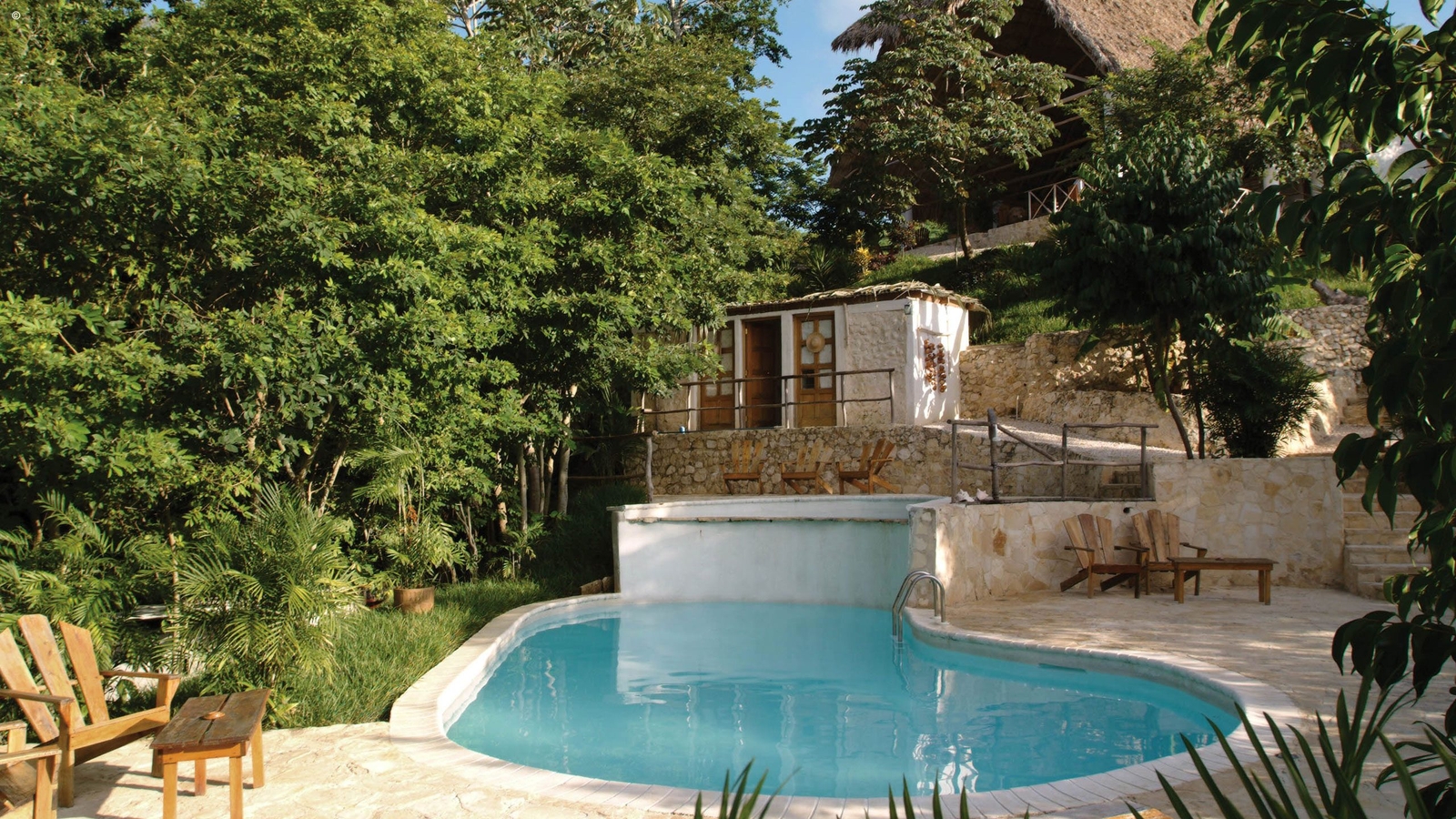Pool area surrounded by trees at La Lancha in Tikal, Guatemala