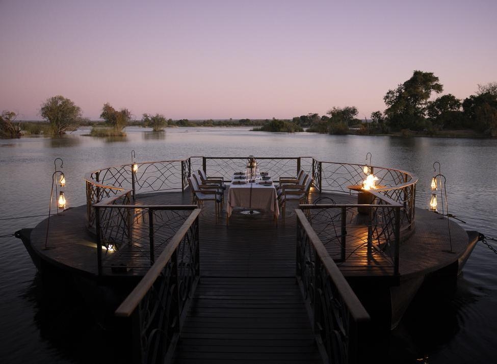 Outdoor deck at Thorntree River Lodge featuring a dining table and sweeping views of the Zambezi River.
