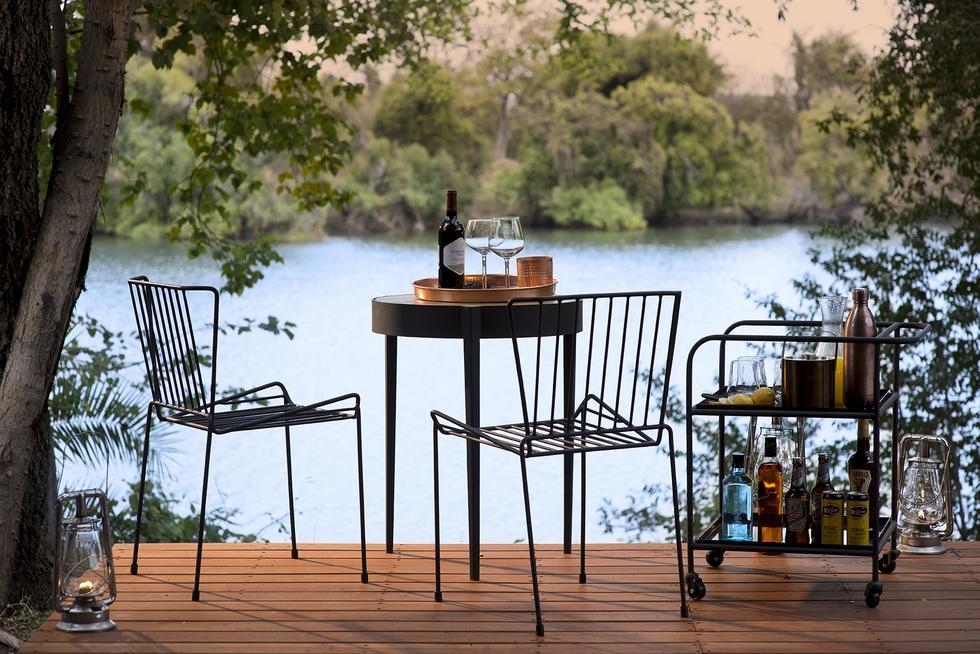 A dining table and two chairs at Thorntree River Lodge overlooking the Zambezi River.