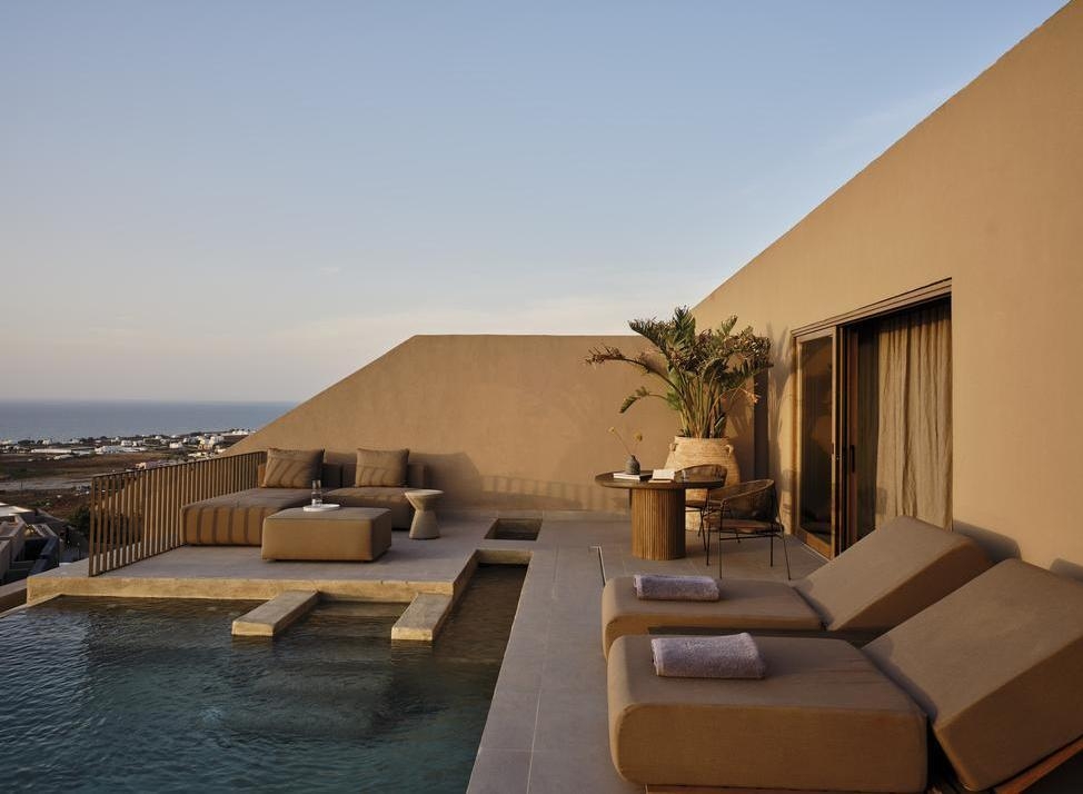 Infinity pool with sunloungers at sunset at Andronis Arcadia