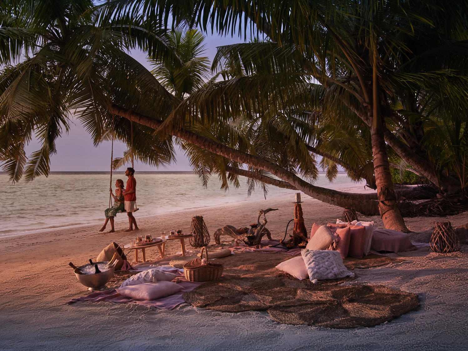 A romantic beachside picnic with a couple at sunset.