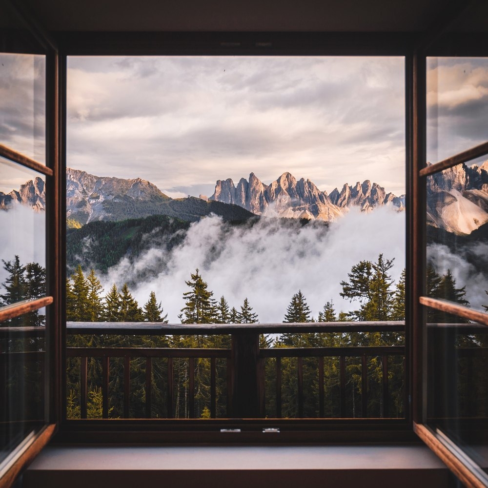 A balcony overlooking forest and mountains at Forestis Dolomites