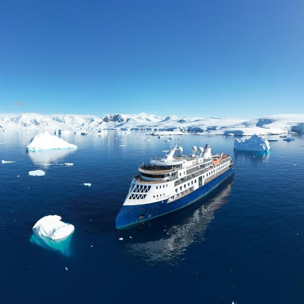An aerial view of Ocean Explorer cruising between icebergs.