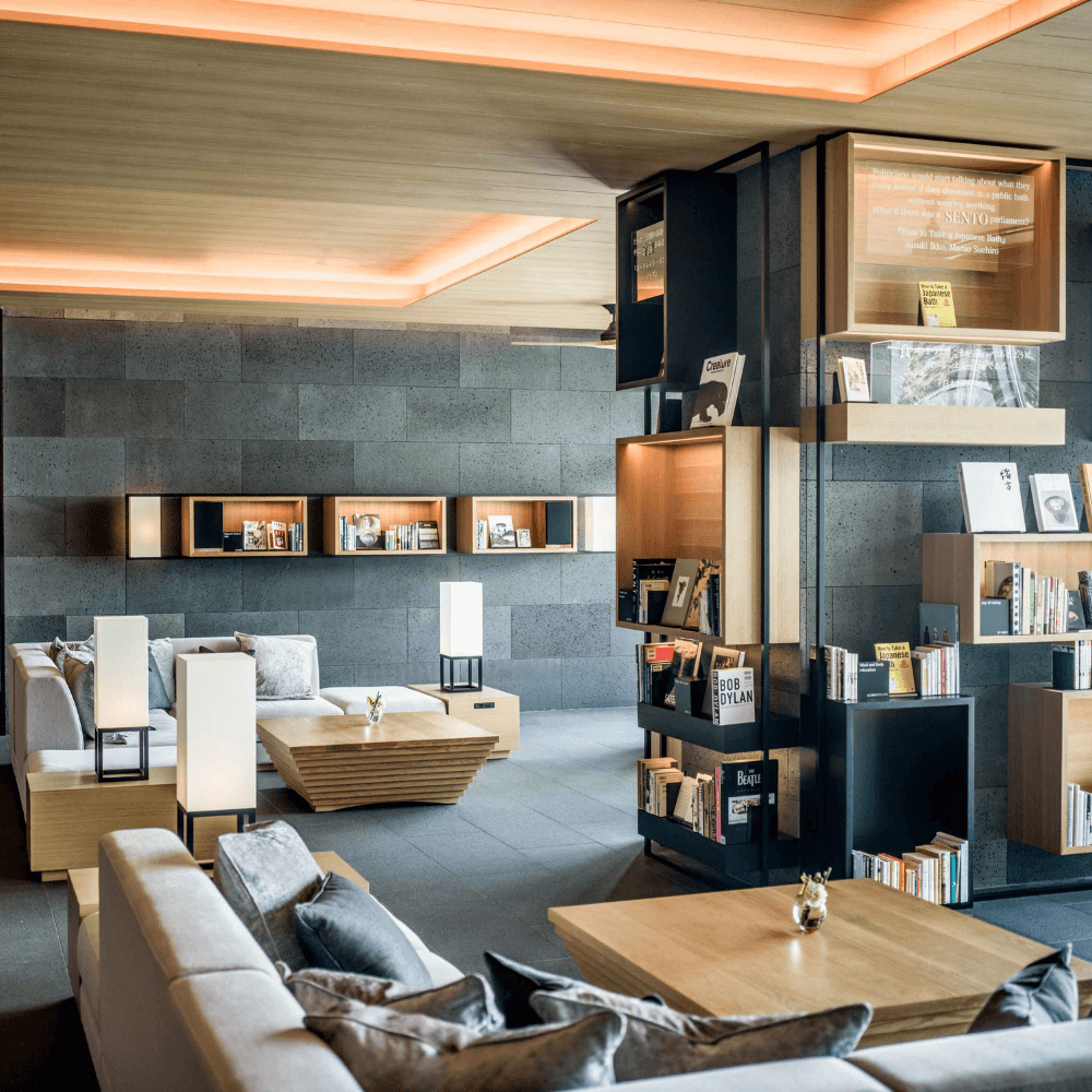 A hotel library with couches and bookshelves