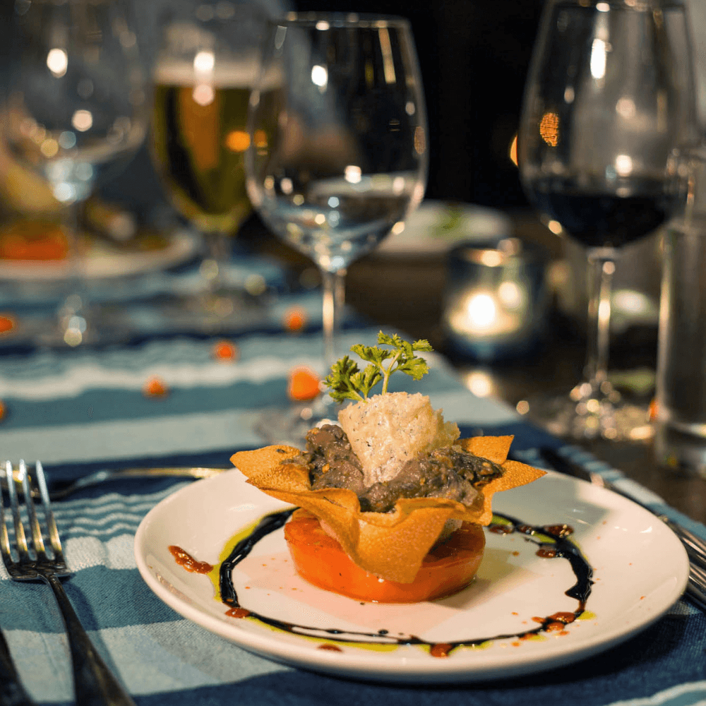 Close-up of a colourful plate of food with wine glasses behind it