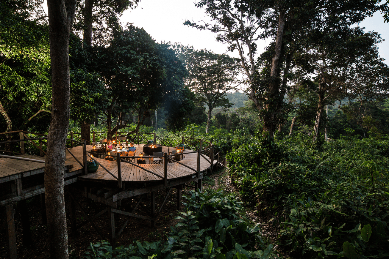 Round raised wooden deck with a table for two, bonfire and views of the forest