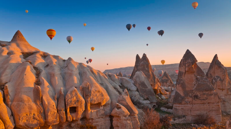 Hot Air Balloons rise up over the Goreme Valley in Cappadocia, Turkey