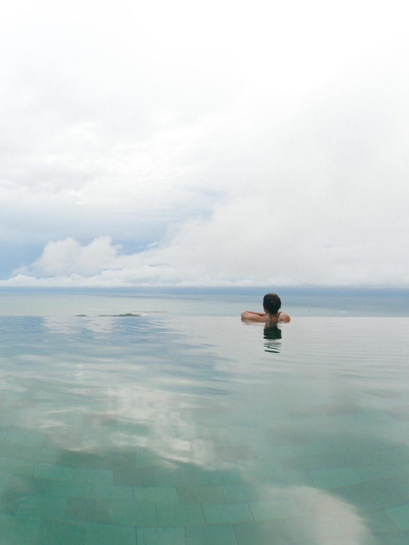 Luxury Costa Rica tours - A woman looking out over the edge of an infinity pool towards the sea