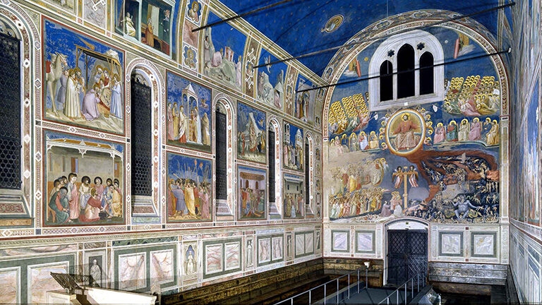 Luxury Italy Tours - Scronvegni Chapel interior, with frescoes covering the walls and ceiling depicting religious scenes from the Bible. The background of the paintings is a royal blue, with white and pink marble details