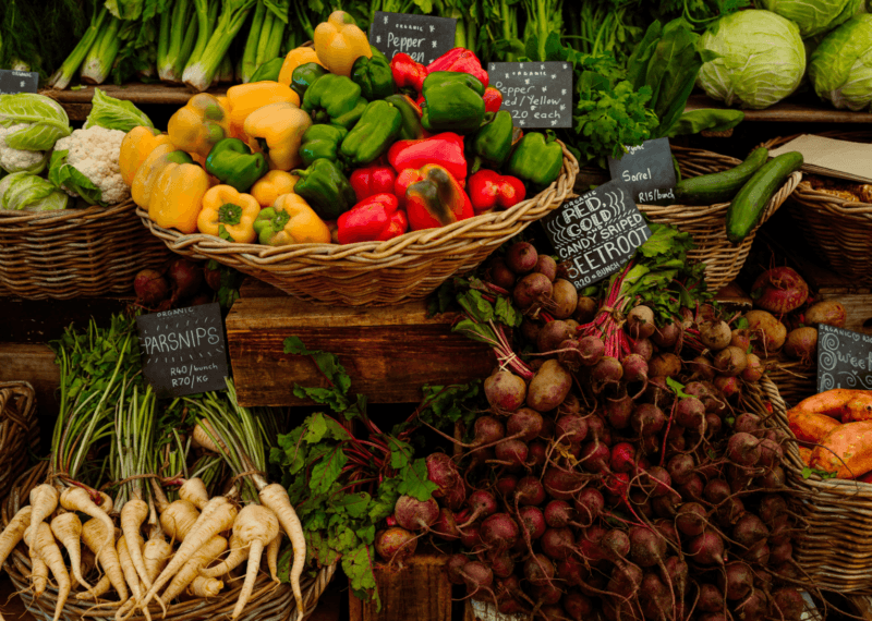 Fresh organic vegetables including red peppers and beetroots for luxury Cape Town vacations at a local market.