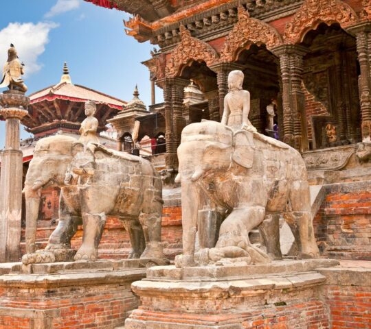 Stone elephant statues and ornate ancient architecture in Durbar Square, Nepal.