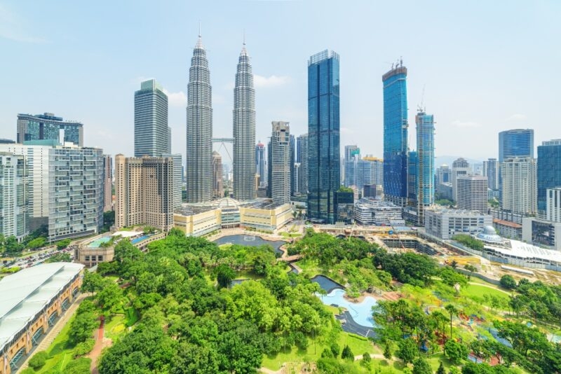 Aerial view of the KLCC Park and the Petronas Twin Towers in Kuala Lumpur, Malaysia. The urban park in Kuala Lumpur City Center is a popular tourist attraction of Asia. Awesome Kuala Lumpur skyline.