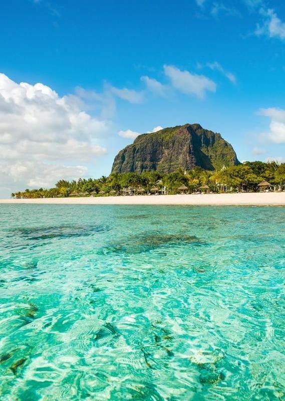 Turquoise ocean with beach and rocky landscape in the background in Mauritius