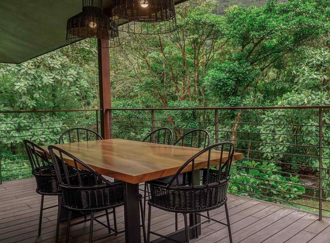 An outdoor dining area overlooking a dense forest.