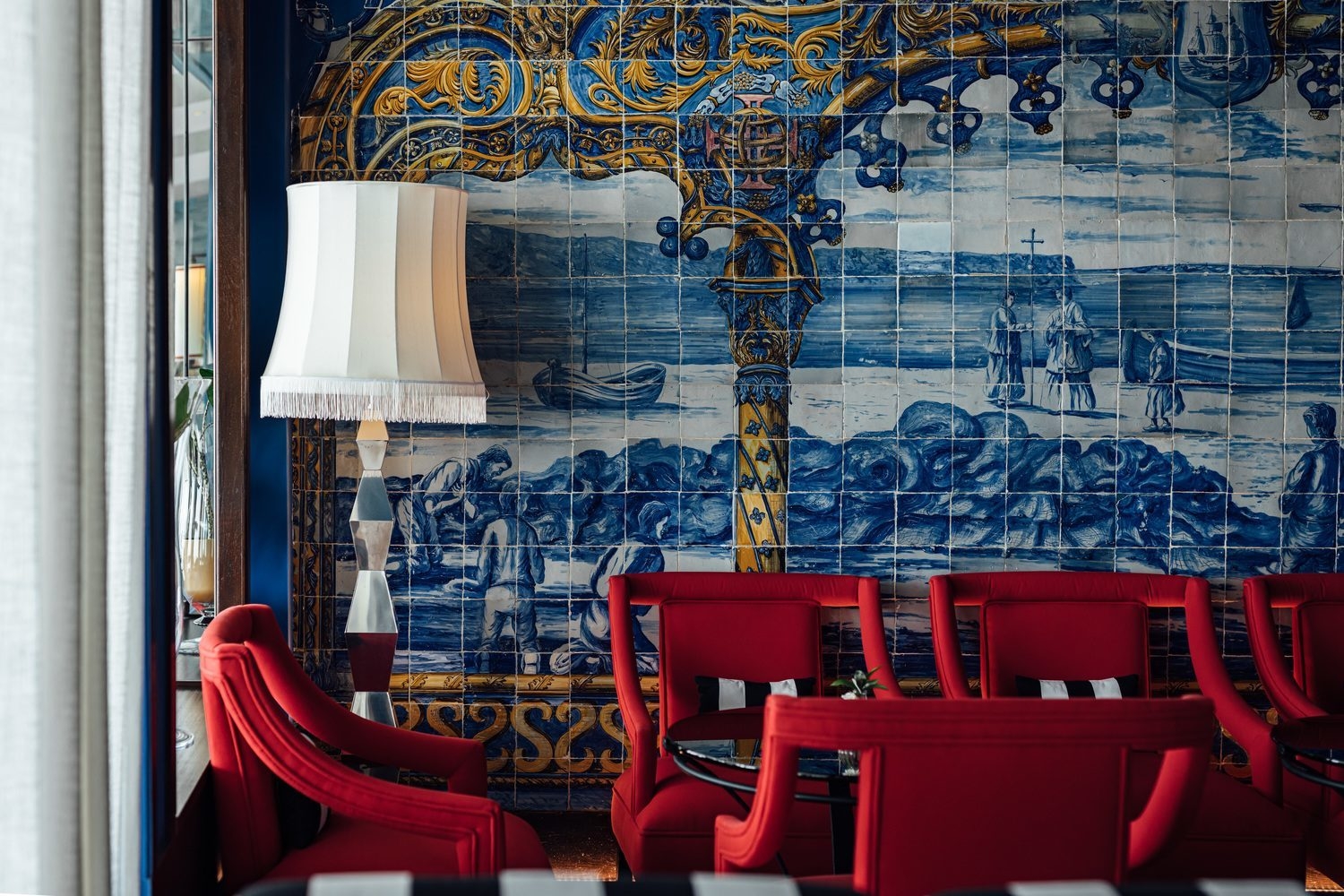 Blue tiled wall with red chairs at Hotel Bela Vista