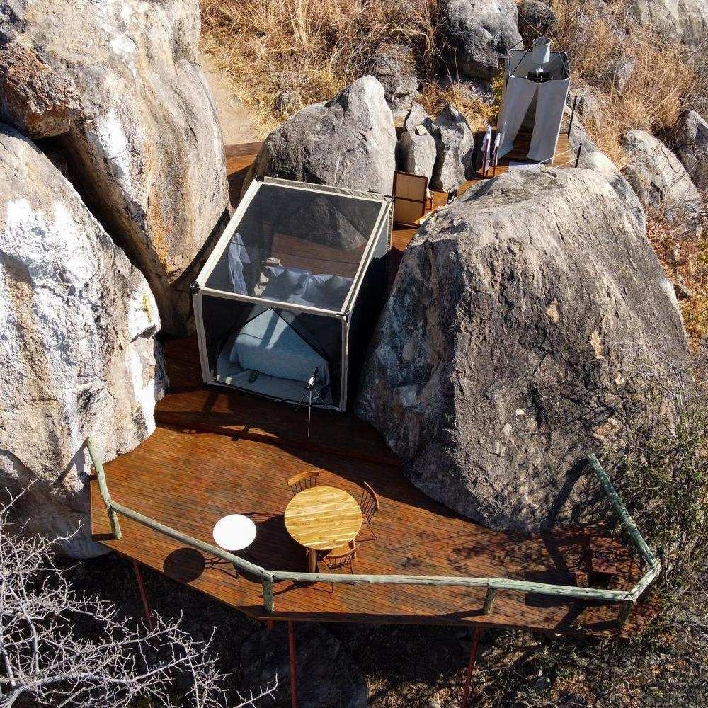 An intimate, outdoor space featuring a bed with a private terrace.