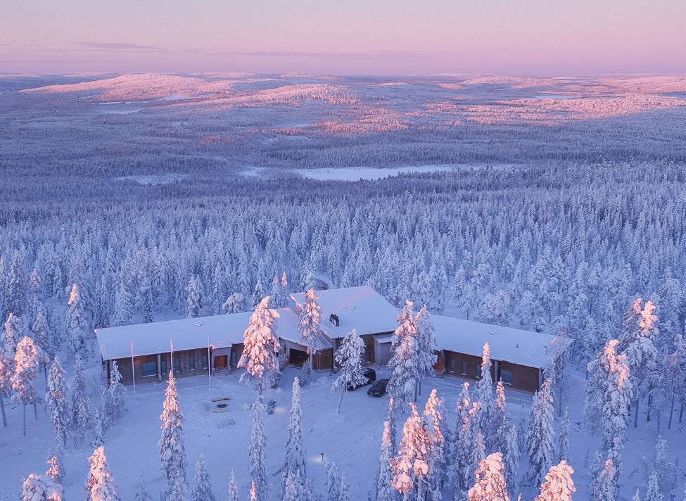 Aerial view of Octola Lodge at sunset surrounded by snow covered trees