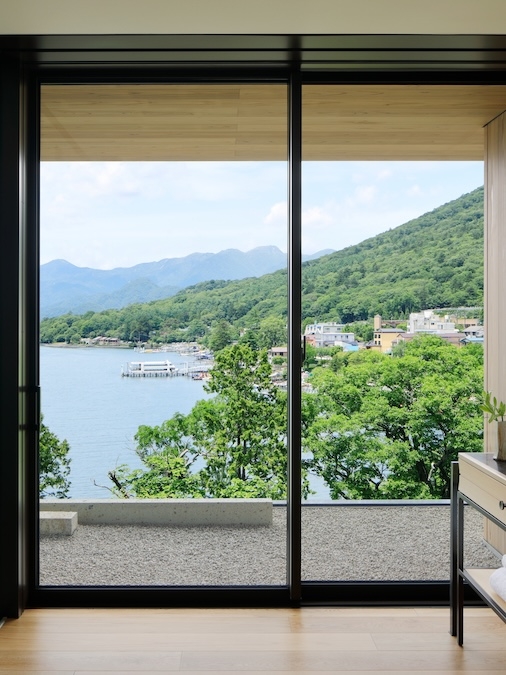 Glass door to balcony with view of lake and trees