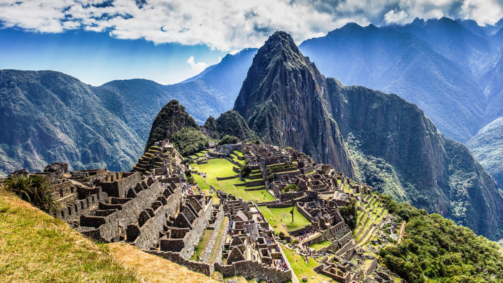 epic expeditions - The ruins of ancient citadel Machu Picchu in the Peruvian mountains on a bright and cloudy day, luxury Machu Picchu tour.