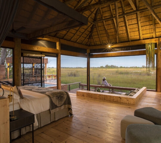 A Vumburu Plains safari camp bedroom with a view of the plains and natural surroundings