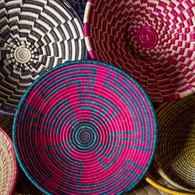 A close-up view of a selection of brightly colored, intricately handwoven Rwandan baskets. Perfect for your luxury Rwanda holidays.