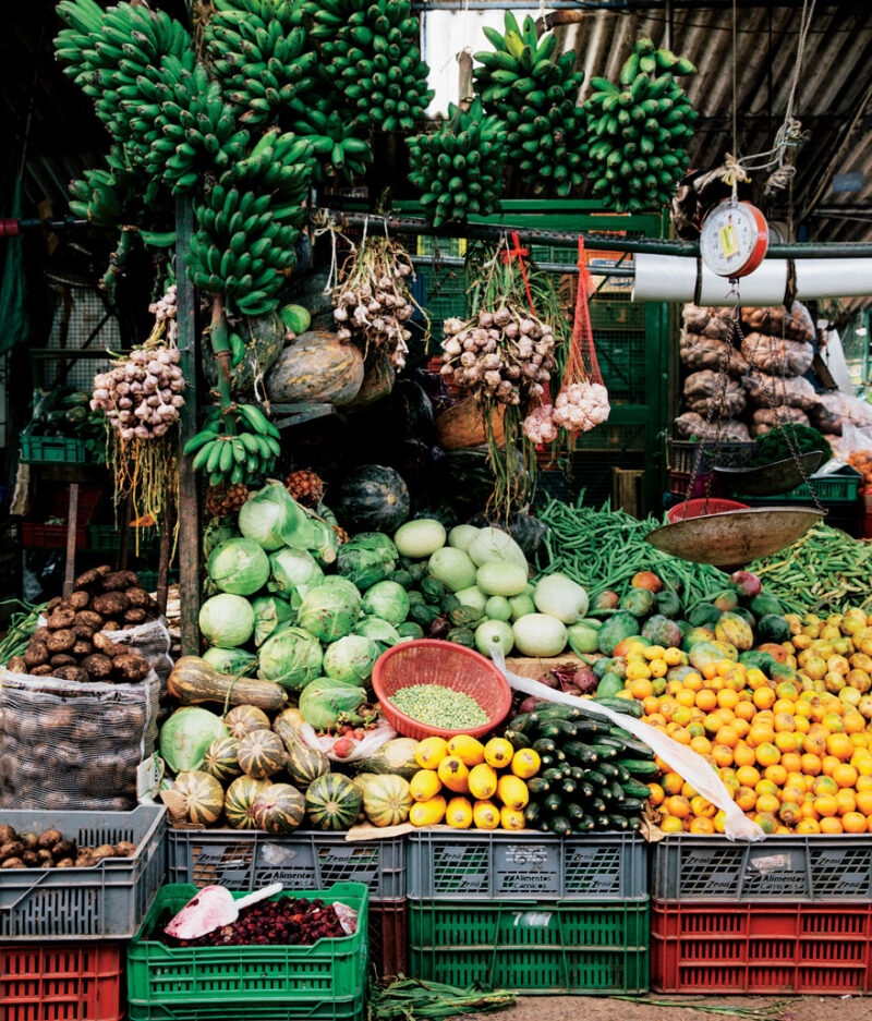 Jacada Colombia - market stall with colourful vegetables and fruit piled high