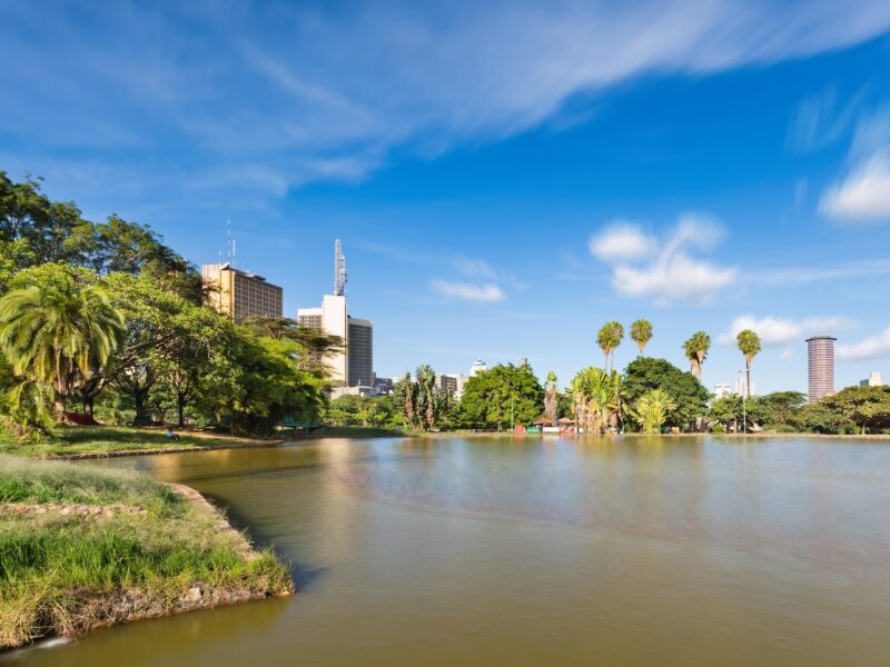 Luxury Kenya Safari Tours - Long exposure of the skyline of Nairobi, Kenya with the beautiful lake in Uhuru Park in the foreground and some blurred boats.