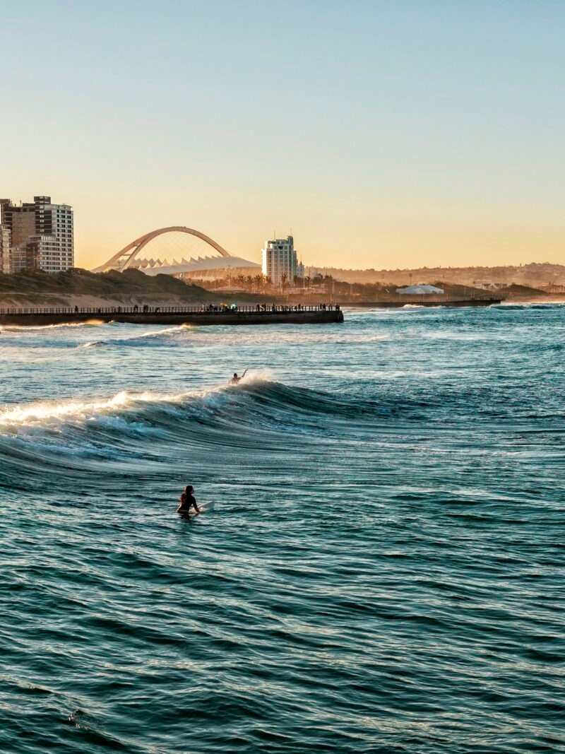Luxury South African Safaris and Tours - Surfers Enjoying the Waves During Sunset in Durban, South Africa