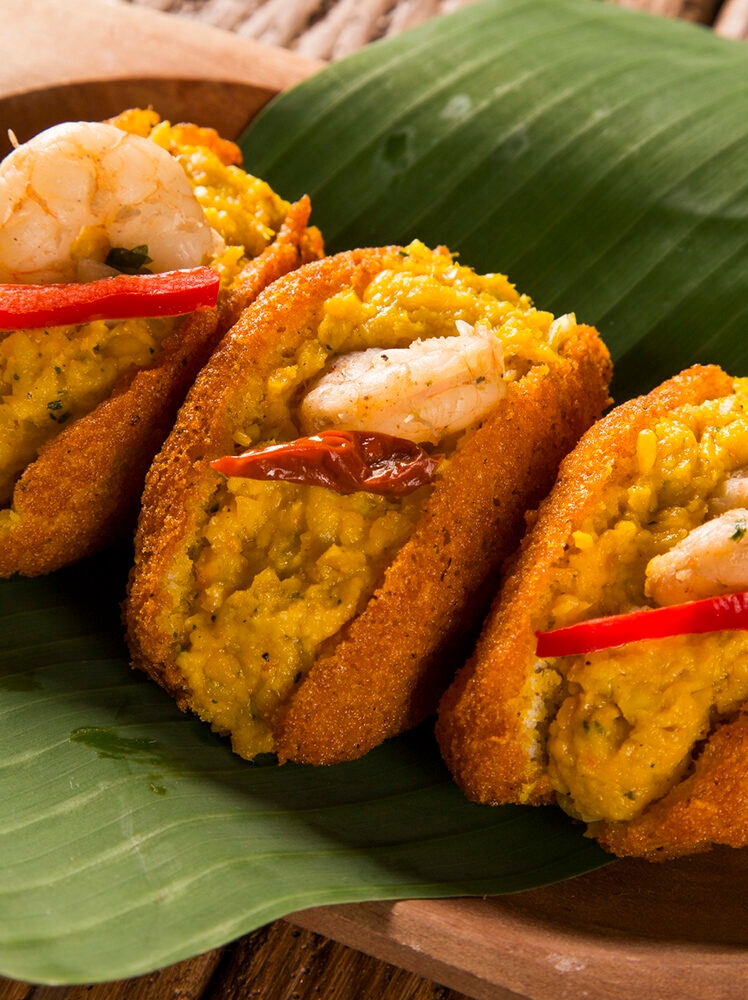 Jacada Travel Brazil - Acaraje - Traditional Brazilian fritters made with black-eyed peas filled with vatapa, caruru, tomato salad and sauteed shrimp. Typical food from Bahia.