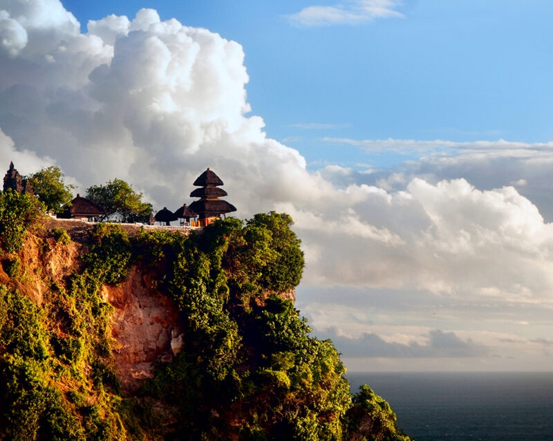 A Balinese temple perched on a high ocean cliff during luxury Bali tours.
