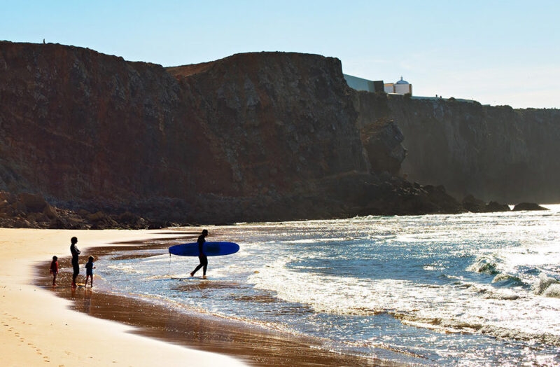 A family surfing on a beach in the Algarve, Portugal