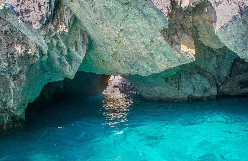 Interior of a sea cave with glowing blue water on luxury Amalfi Coast tours.