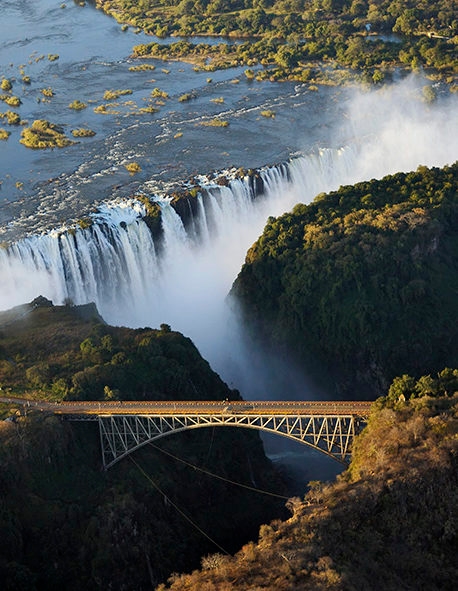 Aerial view of a bridge over a gorge near Victoria Falls during luxury South Africa rail travel.