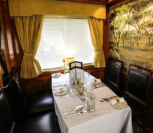 A formal dining table set for four on luxury South Africa rail holidays.