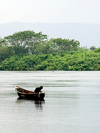 A person in a small boat fishing in still water