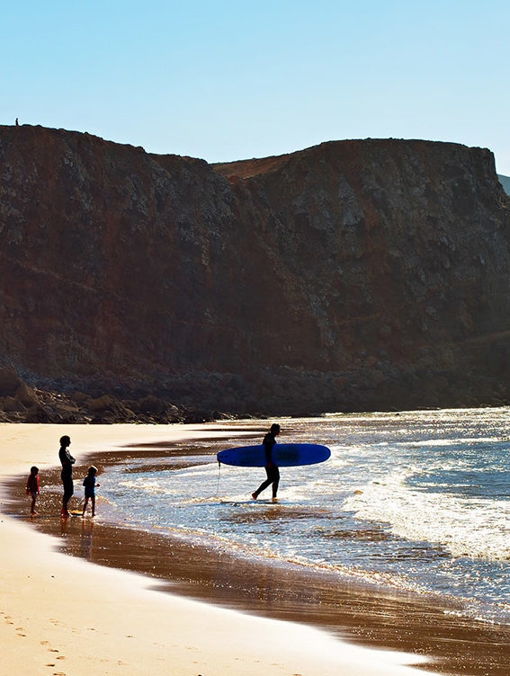 Luxury Grand Tours of Europe - A family surfing on a beach in the Algarve, Portugal
