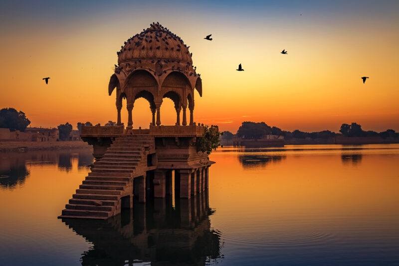 Arts, Culture & History trips - Ancient temple at Gadi Sagar (Gadisar) lake Jaisalmer Rajasthan, with birds flying past at sunset
