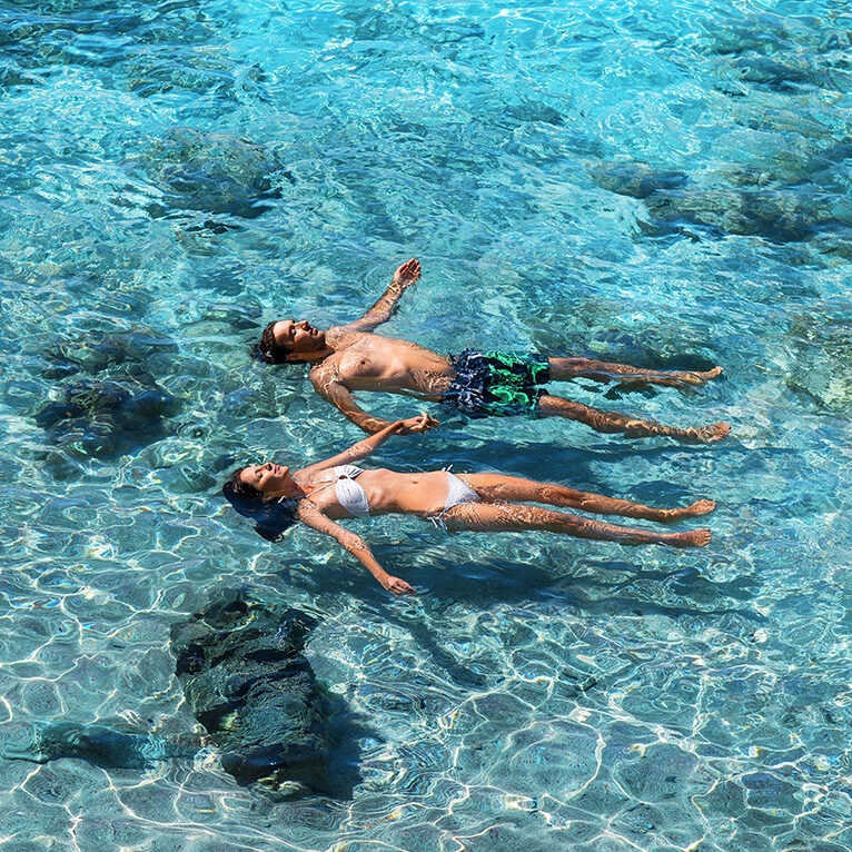 Happy couple swimming in the transparent turquoise sea