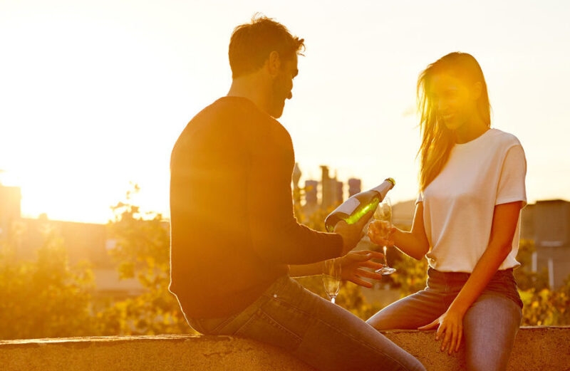 Two people sharing champagne on their balcony