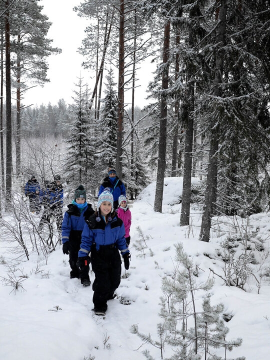 People walking through a snowy forest